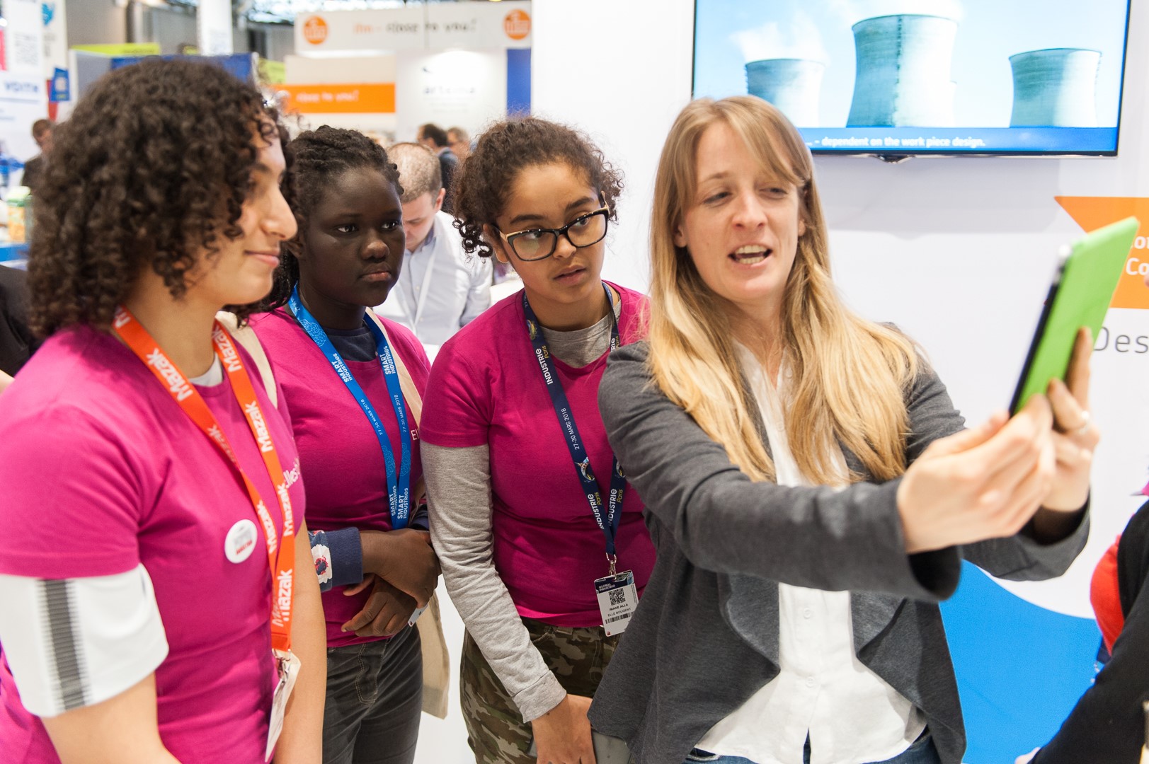 Une marraine explique son métier à des collégiennes Elles Bougent au Salon Global Industry pendant la Semaine de l'Industrie